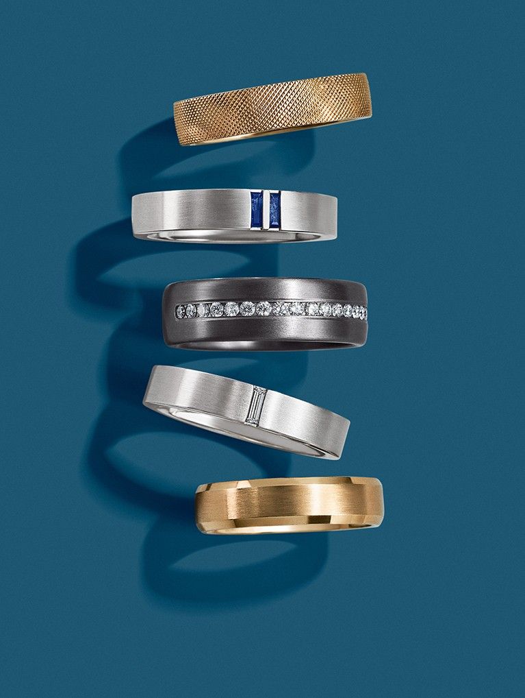 Assortment of gold, gemstone, and alternative metal men’s wedding rings.